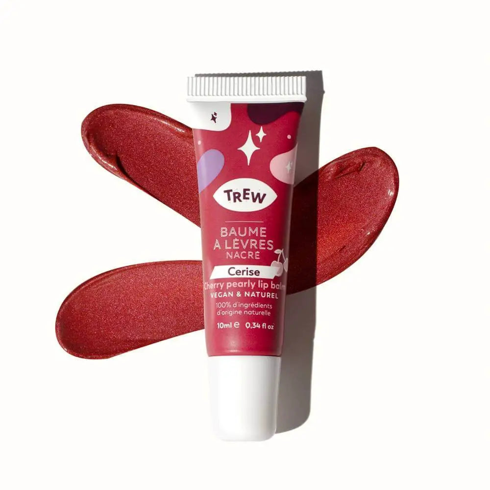 Tube de baume à lèvres Trew teinté cerise nacrée posé sur une texture crémeuse et brillante de la même couleur.