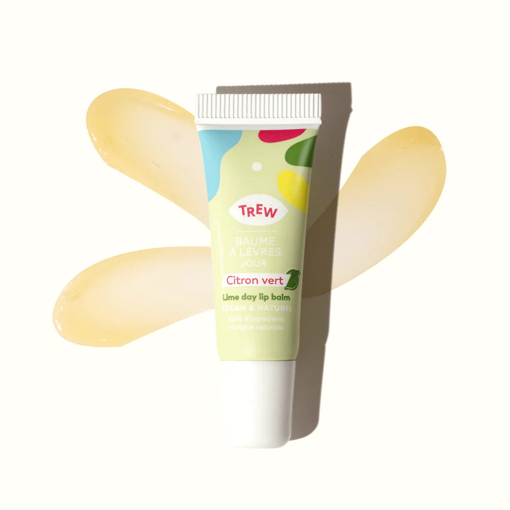 Lime-scented lip balm in a light green squeeze tube with colorful abstract shapes, set against a smear of balm.