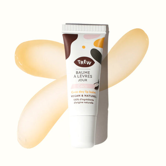 Tube de baume à lèvres Trew coco sur fond blanc, entouré de deux touches de texture baume translucide et dorée.
