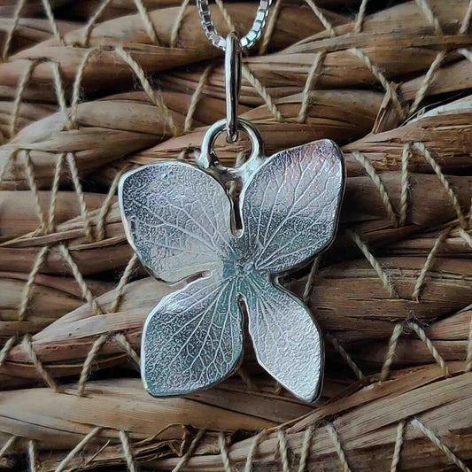 Colgante de mariposa de plata esterlina, acabado brillante, con detalles texturizados. Ideal para estilo elegante.