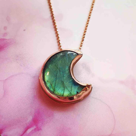 Collar con colgante en forma de luna, color verde y dorado, hecho de resina y metal. Ideal para un look moderno.