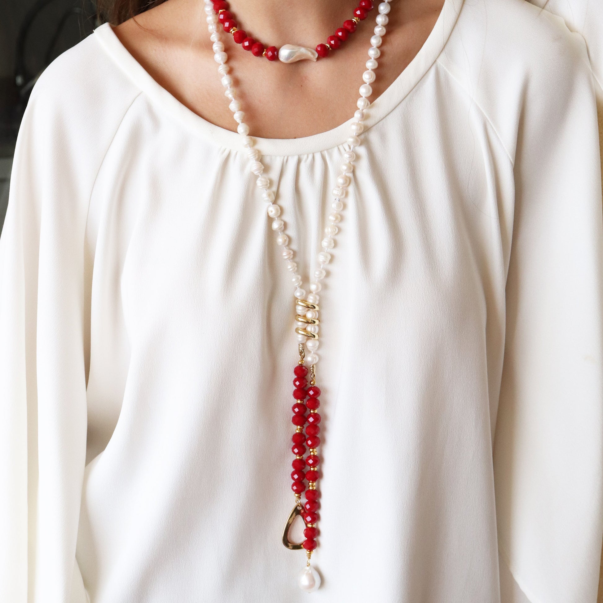 Collar de perlas blancas y rojas con detalle dorado, estilo elegante y moderno, ideal para ocasiones especiales.