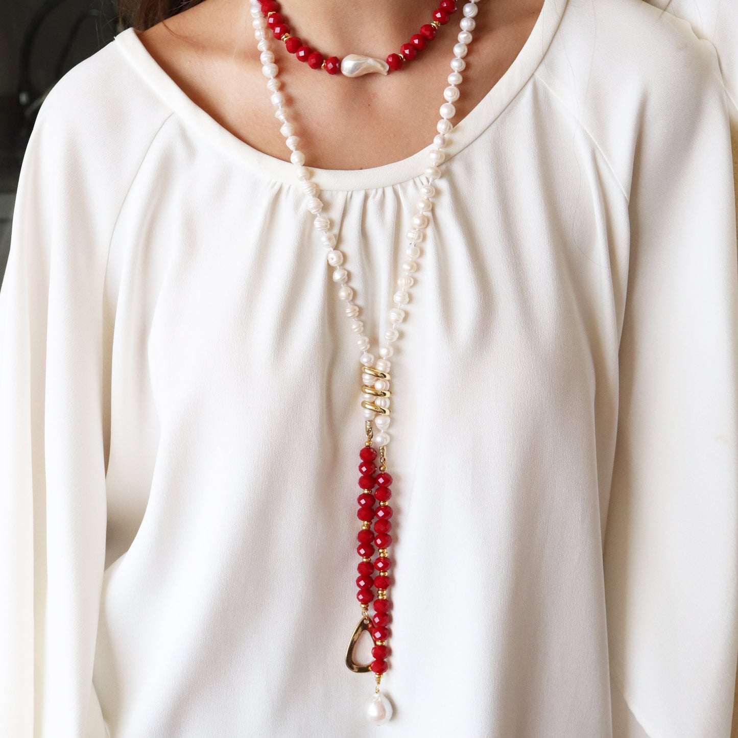 Collar de perlas blancas y rojas con detalle dorado, elegante y moderno, ideal para cualquier ocasión.