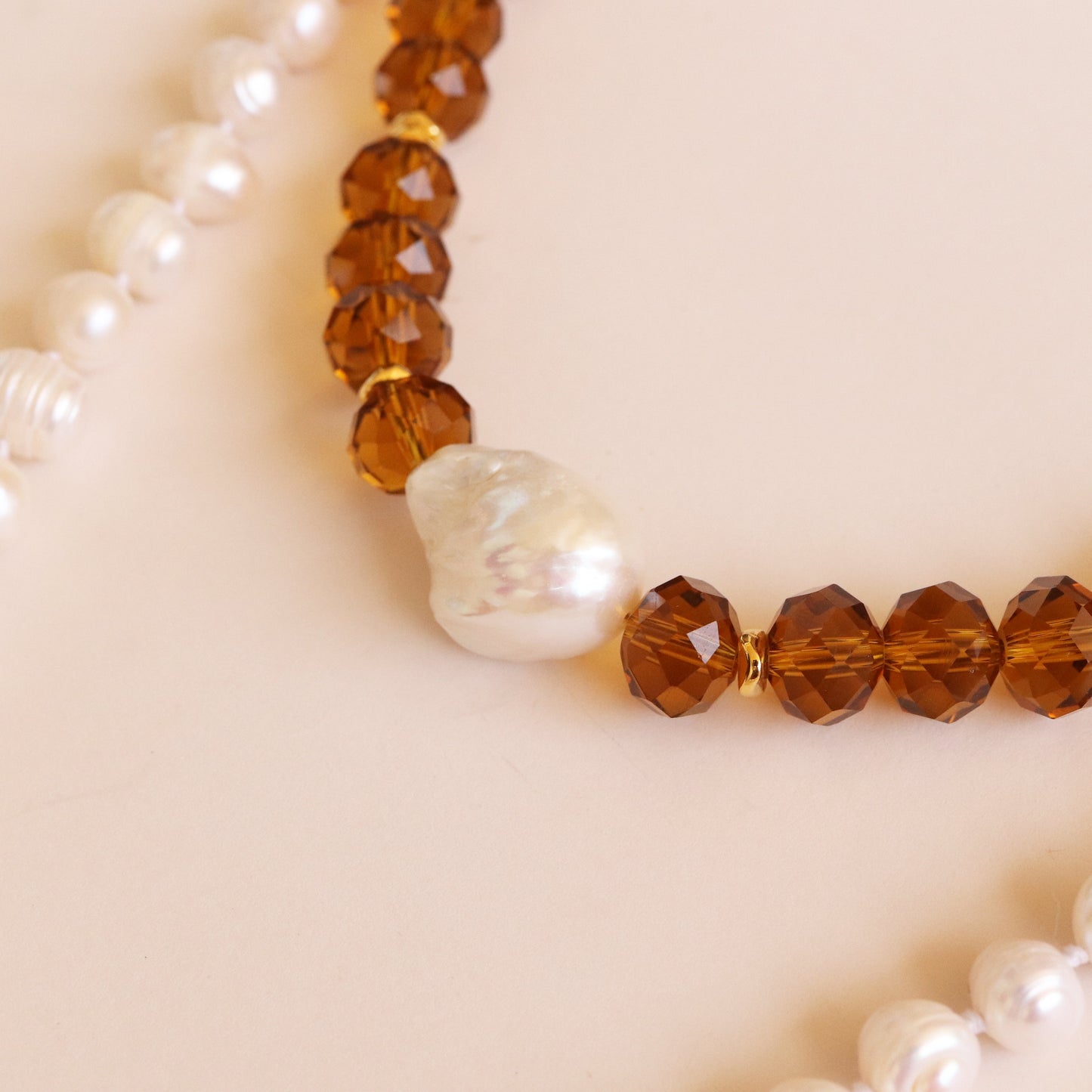 Collar de perlas blancas y ámbar facetado, con una perla irregular en el centro, elegante y artesanal.