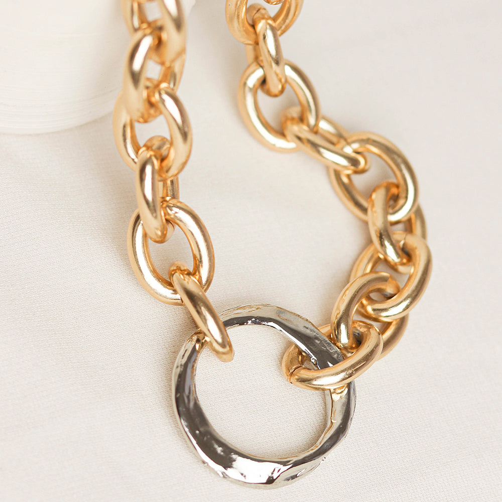 Collar de cadena dorada y plateada, diseño moderno con eslabones grandes y un aro texturizado.