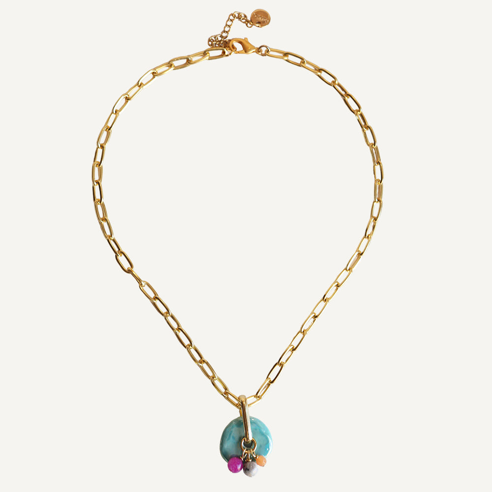 Collar dorado con eslabones, charm de piedra turquesa y cuentas rosa y gris. Perfecto para un look elegante y moderno.