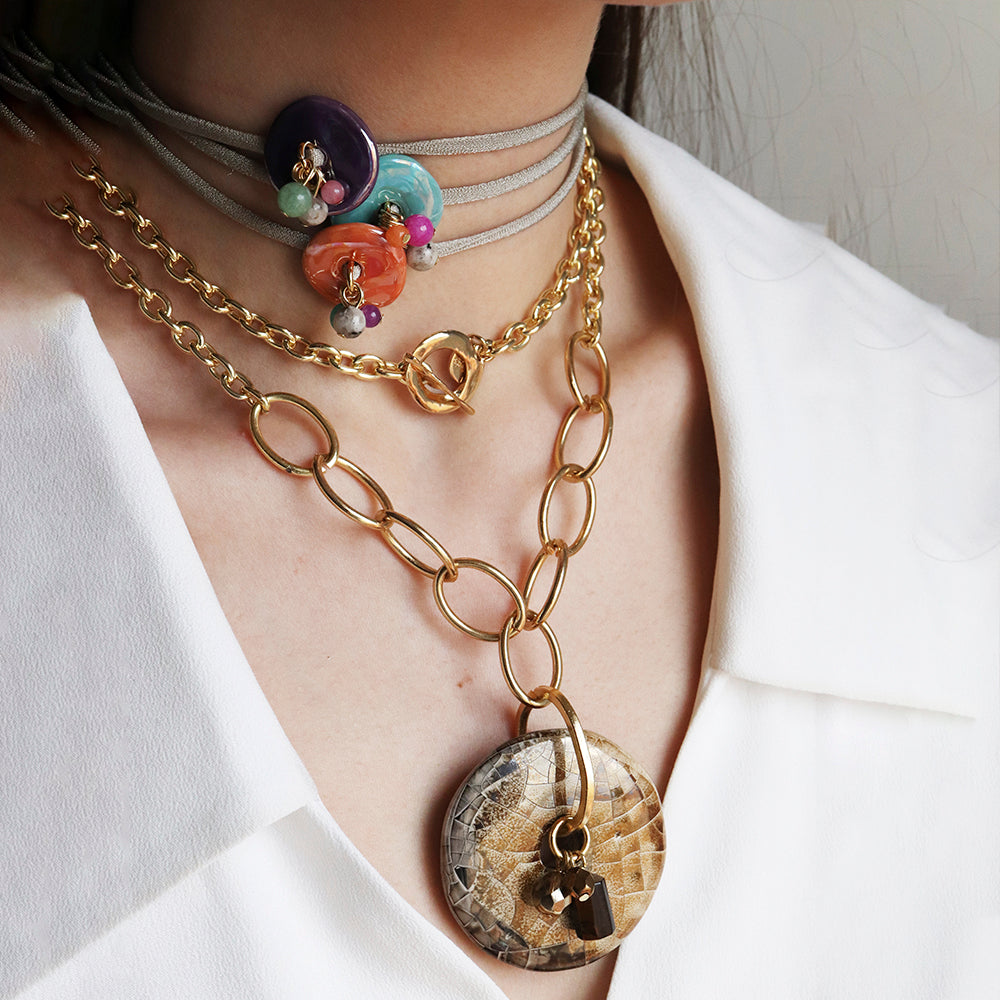 Collares en tonos oro y multicolor, con cadena gruesa y detalles de perlas, estilo bohemio y moderno.