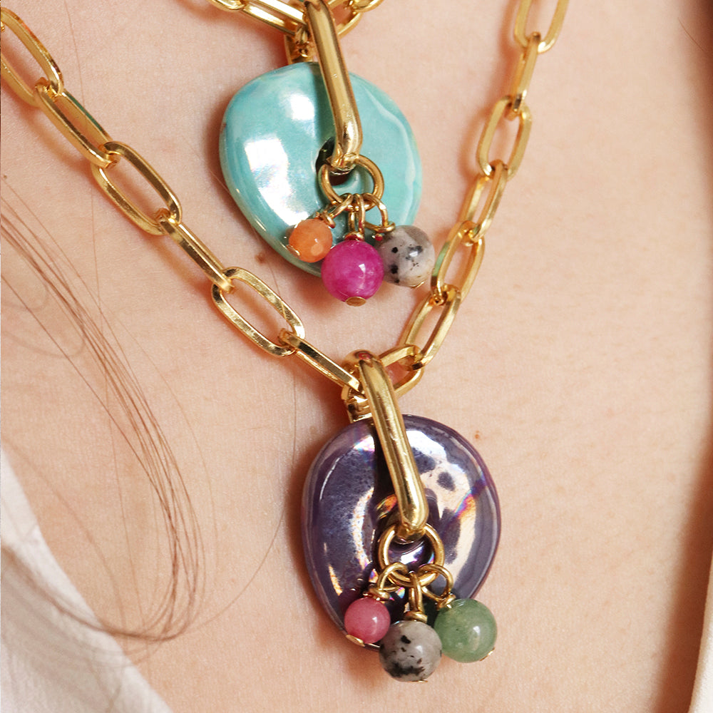 Collares de eslabones dorados con colgantes de cerámica azul y morado, decorados con piedras multicolor.