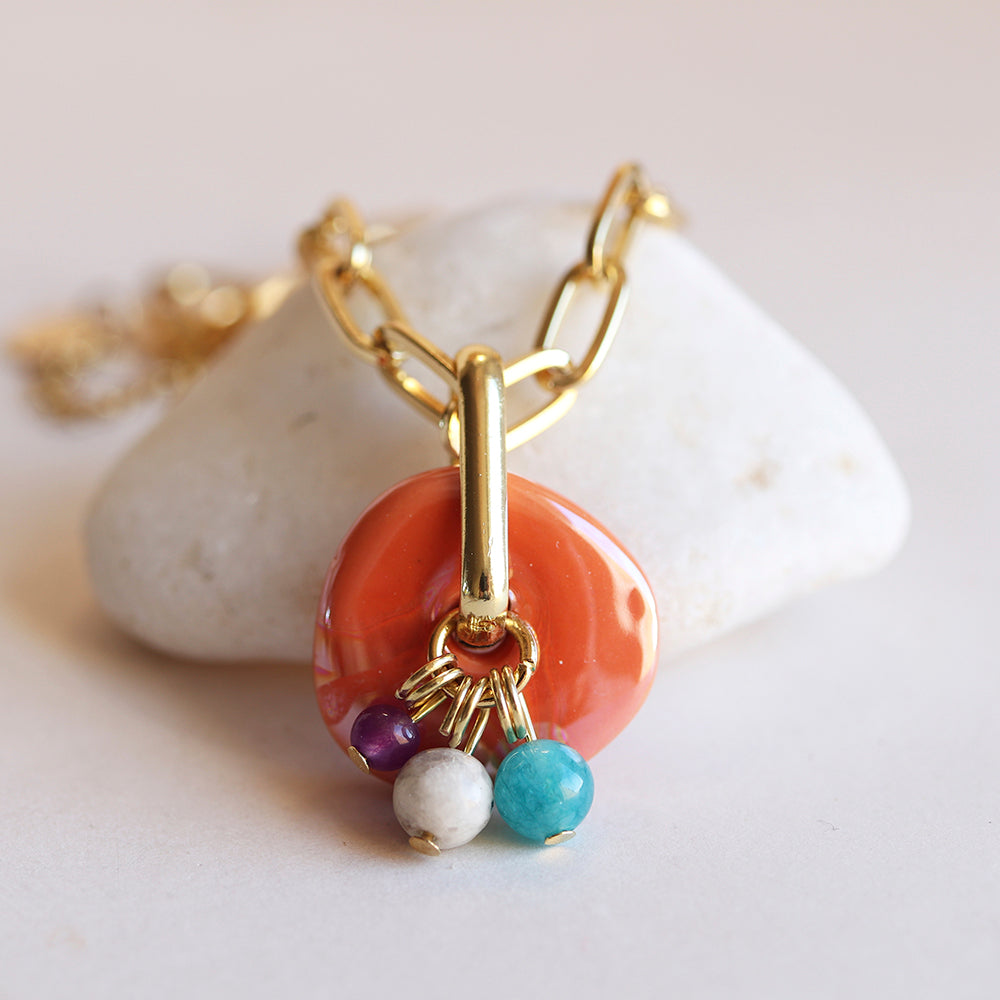 Collar dorado con colgante de piedra naranja y cuentas de turquesa, blanco y morado, estilo bohemio.