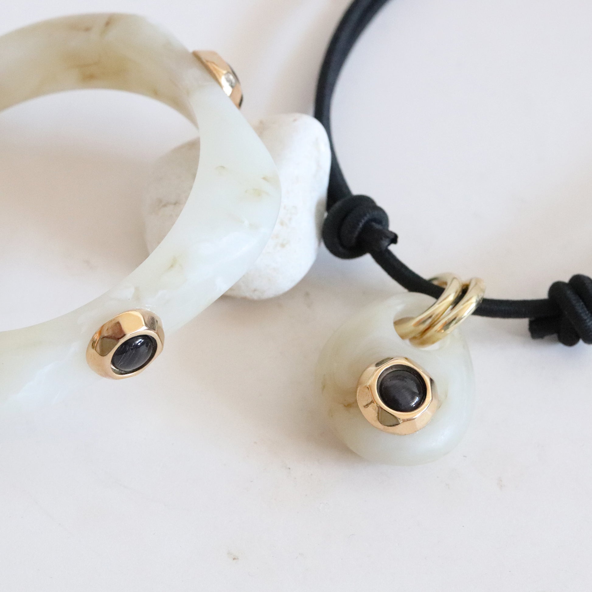 Pulsera y colgante de jade verde con detalles en dorado y negro, estilo moderno y elegante.
