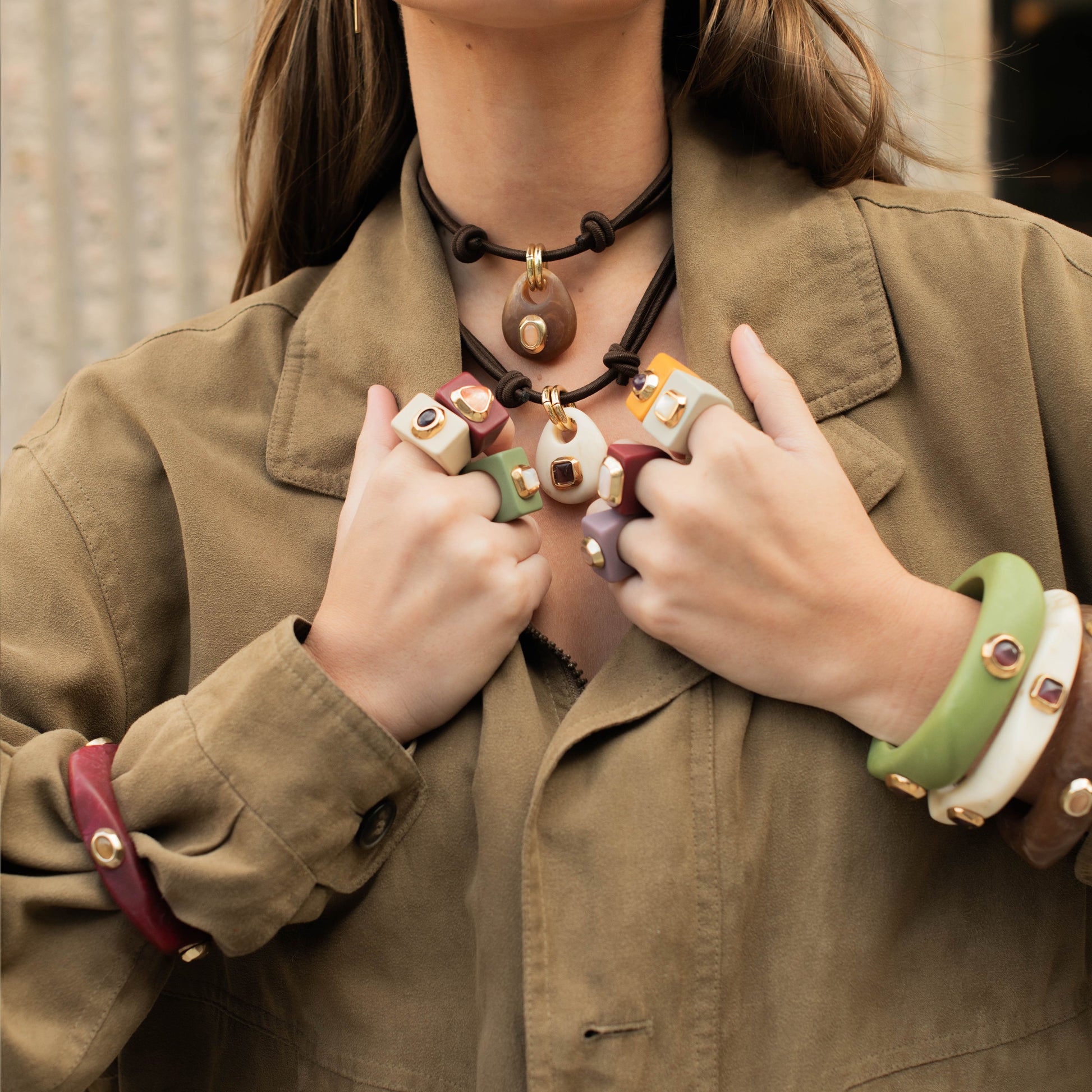 Conjunto de joyas de cerámica en colores verde, rojo y blanco, con collares y anillos elegantes.