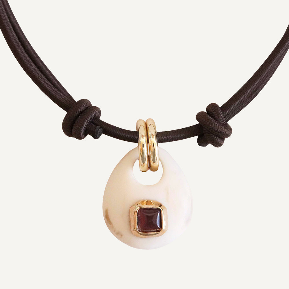 Collar de concha blanca con joya cuadrada color burdeos y cadena de cuerda marrón. Ideal para un look bohemio.