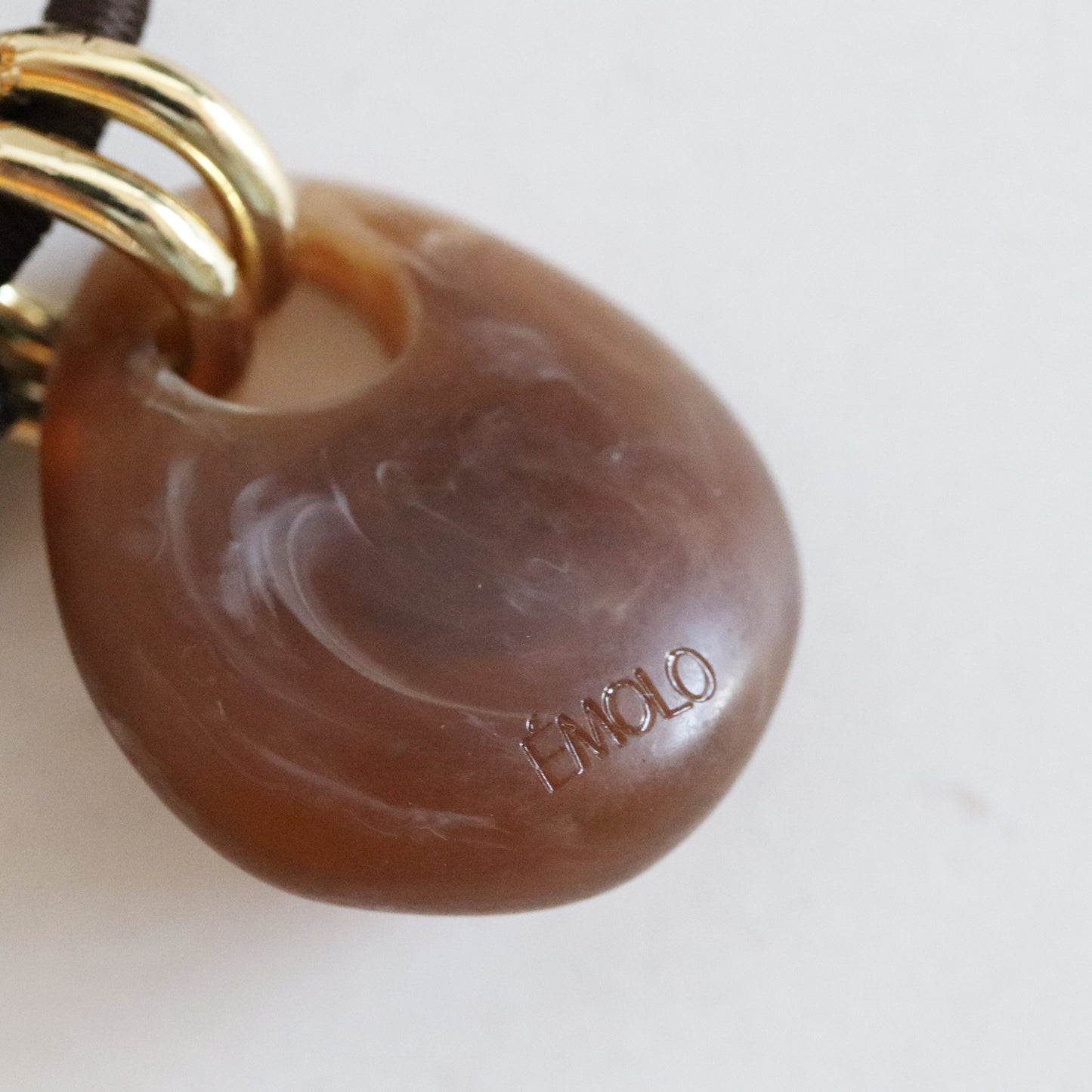 Colgante de ágata marrón con dorados, estilo moderno y elegante, ideal para un toque sofisticado en cualquier atuendo.
