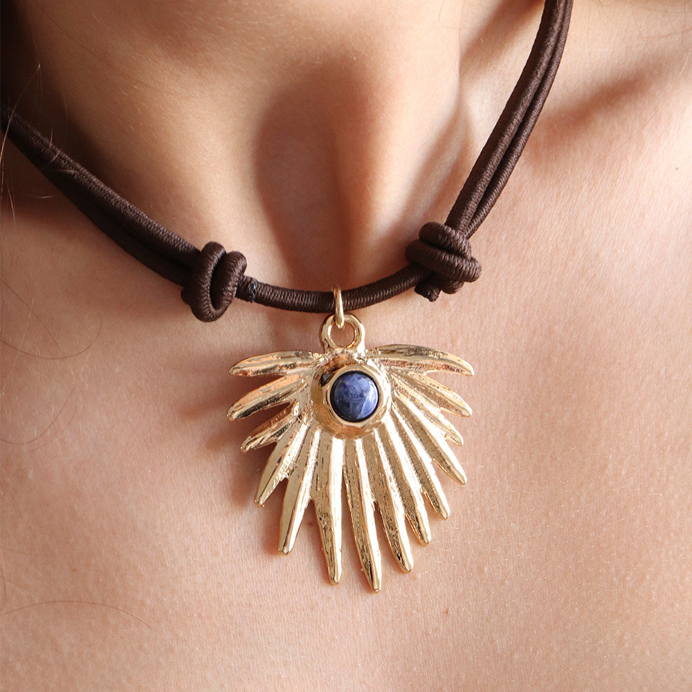 Collar bohemio de cuerda marrón con colgante dorado y piedra azul en forma de ala.