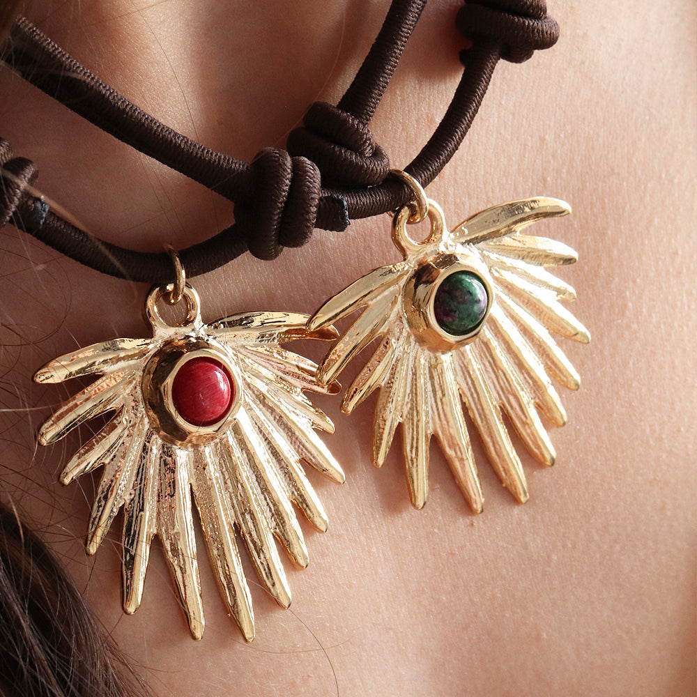 Collares de ala dorada con piedras roja y verde, estilo bohemio, sobre cuerda marrón.