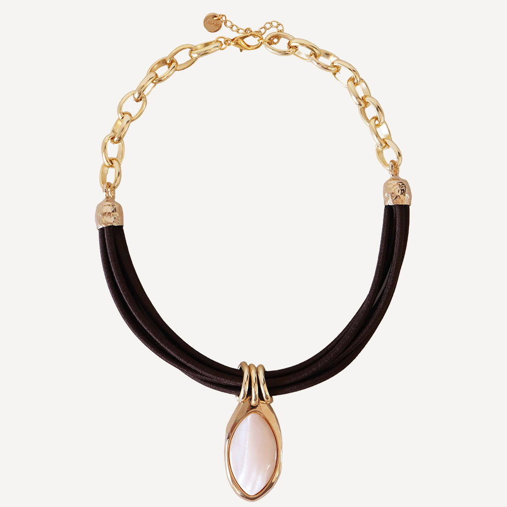 Collar de cadena dorada con elemento rosa y cinta de tela negra, estilo moderno y elegante.