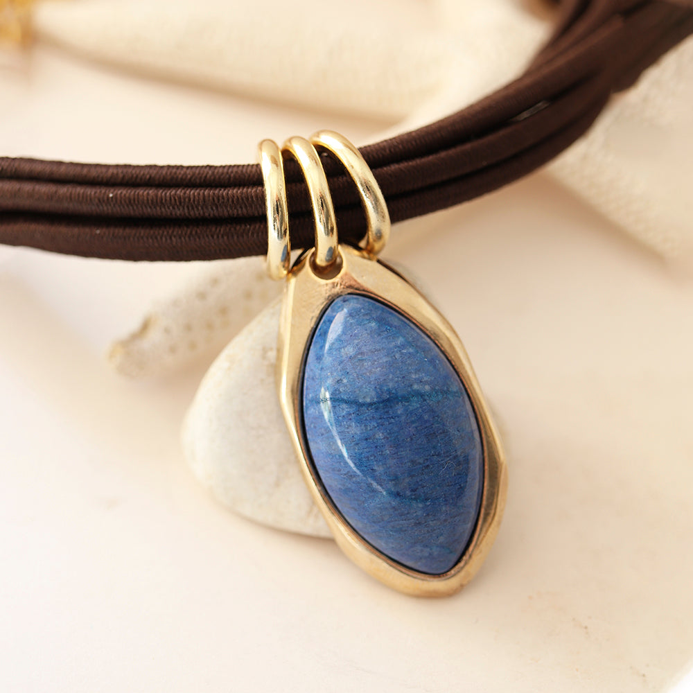 Collar con colgante de lapislázuli en forma de lágrima, marco dorado y cadena de cuerda marrón. Ideal para un estilo elegante.