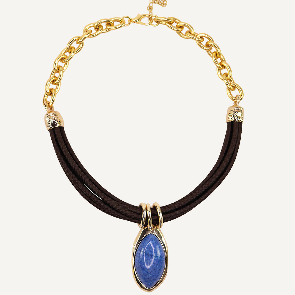 Collar de cadena dorada con piedra azul en forma de gota y cuerda negra, estilo moderno y elegante.