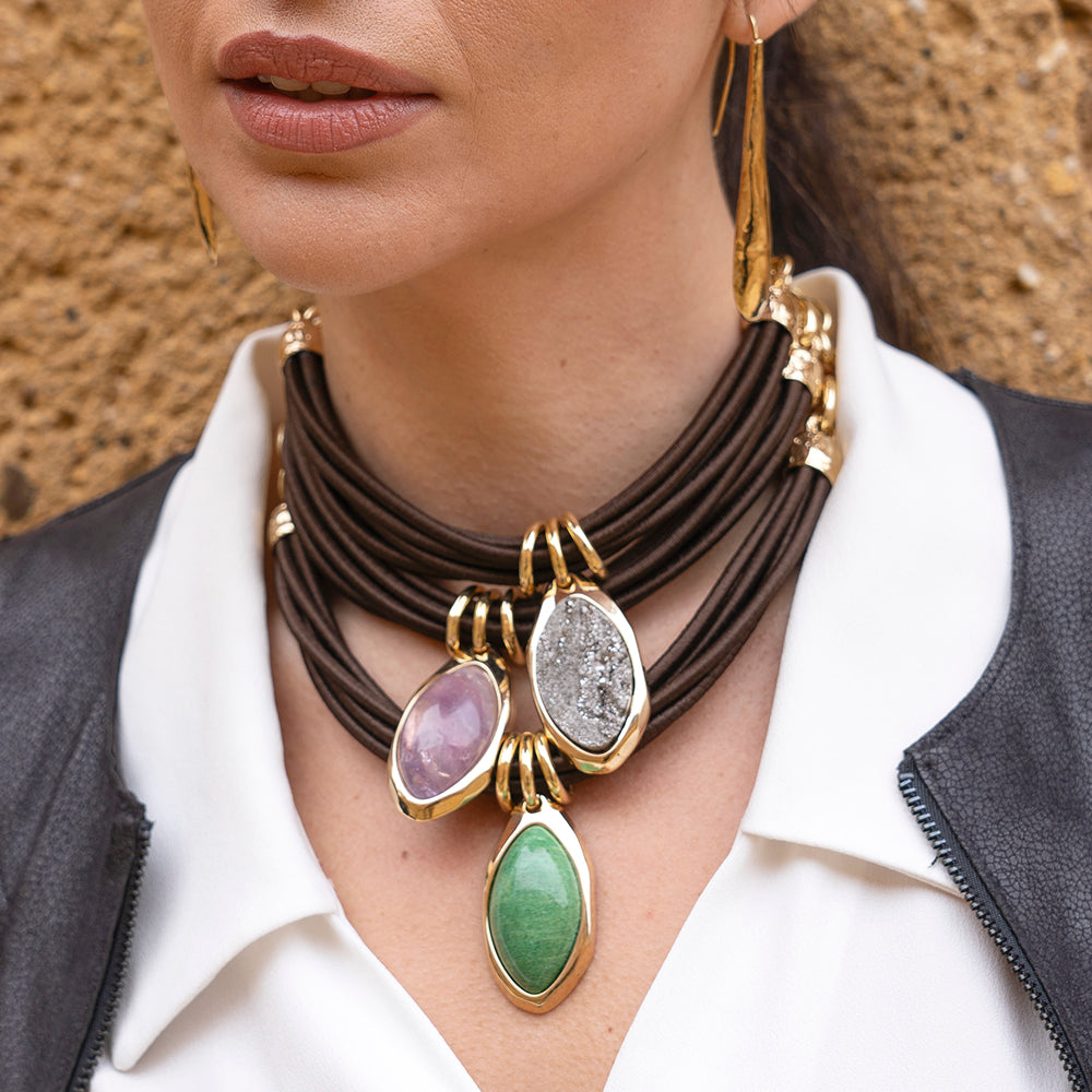 Collar de cuero marrón con piedras preciosas morada, gris y verde en un elegante estilo moderno y contemporáneo.