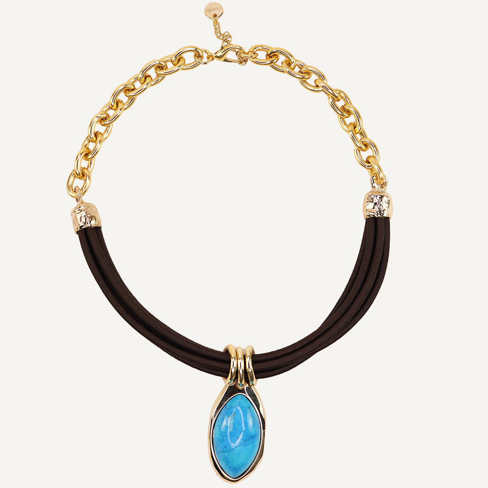 Collar de cadena dorada con detalle azul en forma de lágrima y cordón negro. Estilo moderno y elegante.