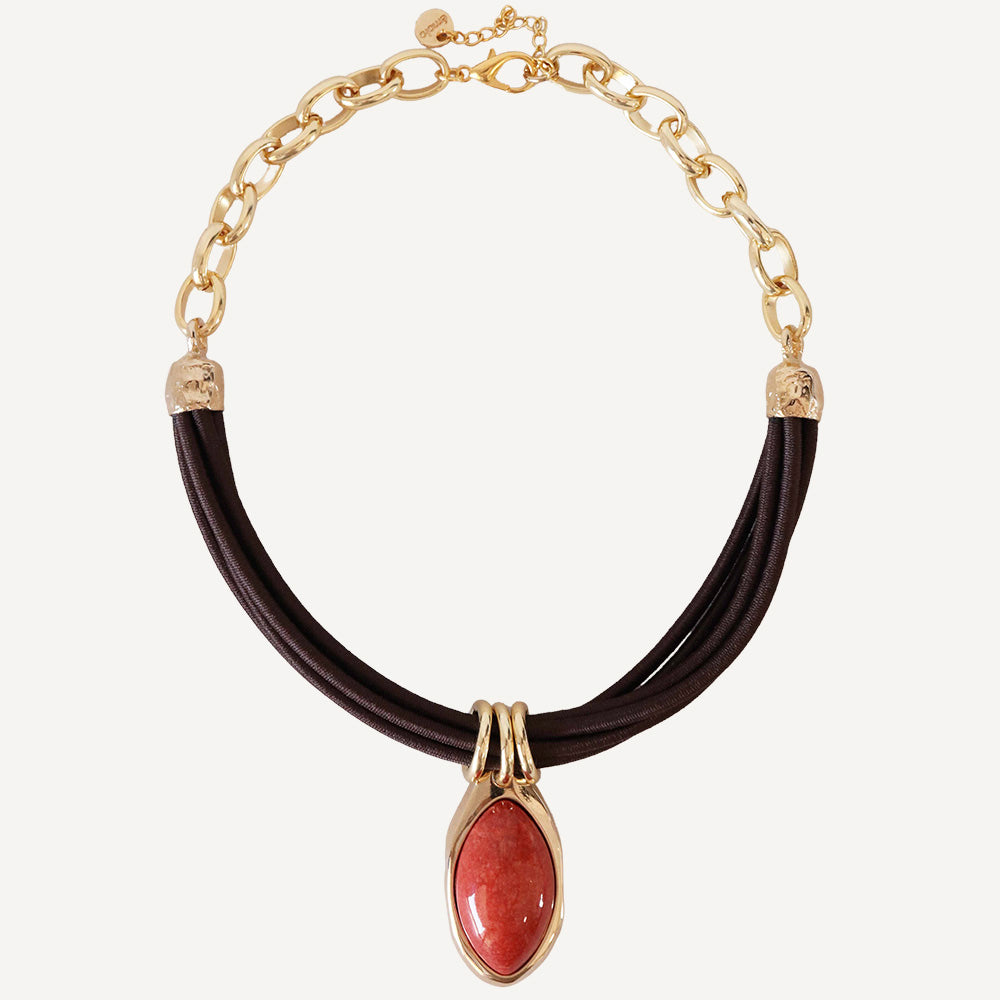 Collar de cuero marrón con detalle en piedra roja y cadena dorada, estilo elegante y moderno.