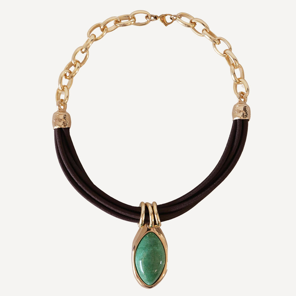 Collar de cadena dorada con piedra verde y cordón negro, estilo elegante y moderno.
