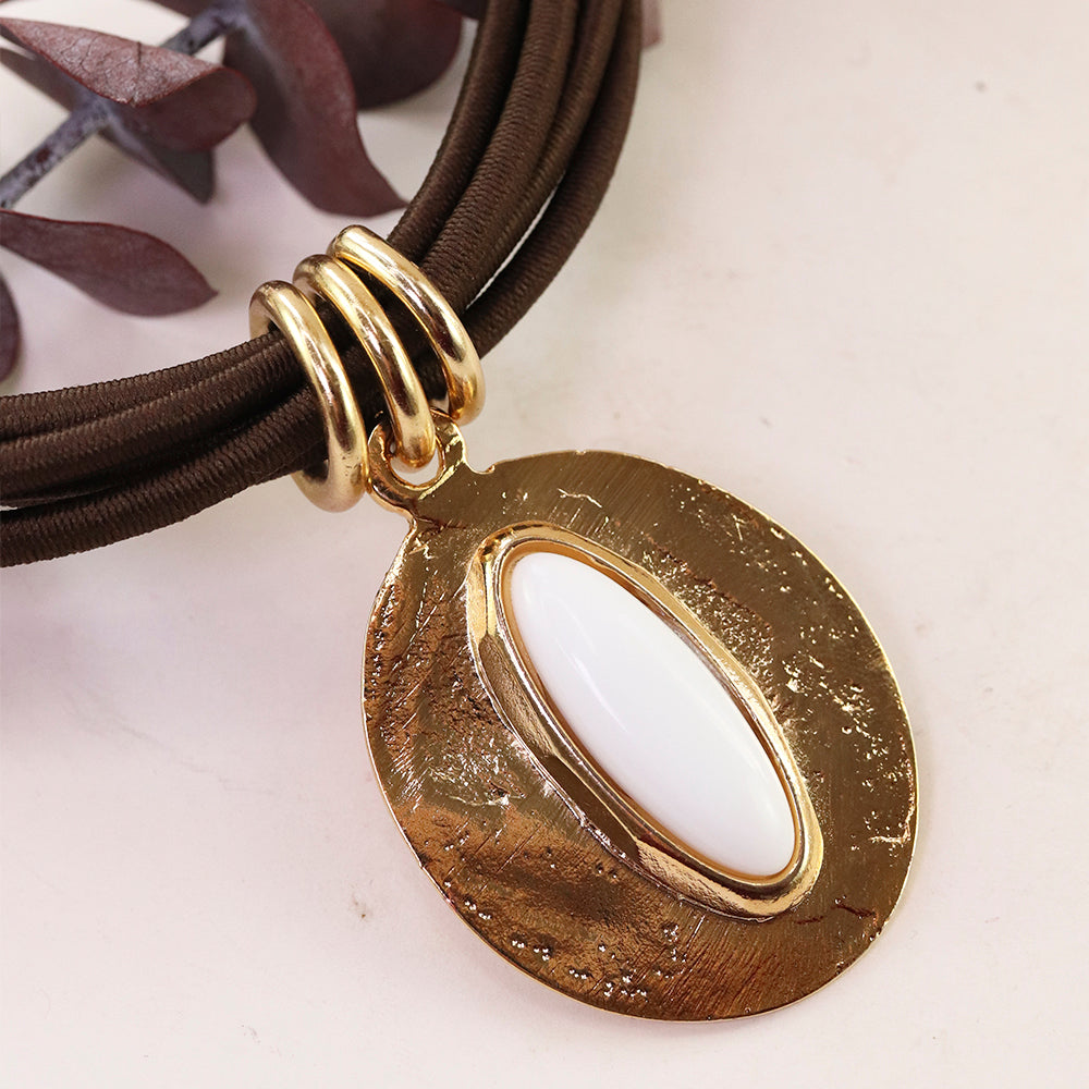 Collar moderno en tonos dorados y marrones con colgante ovalado blanco y textura metálica. Perfecto para ocasiones casuales.