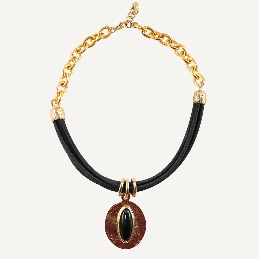 Collar moderno de cadena dorada, cuero negro y colgante ovalado rojo con gema negra.
