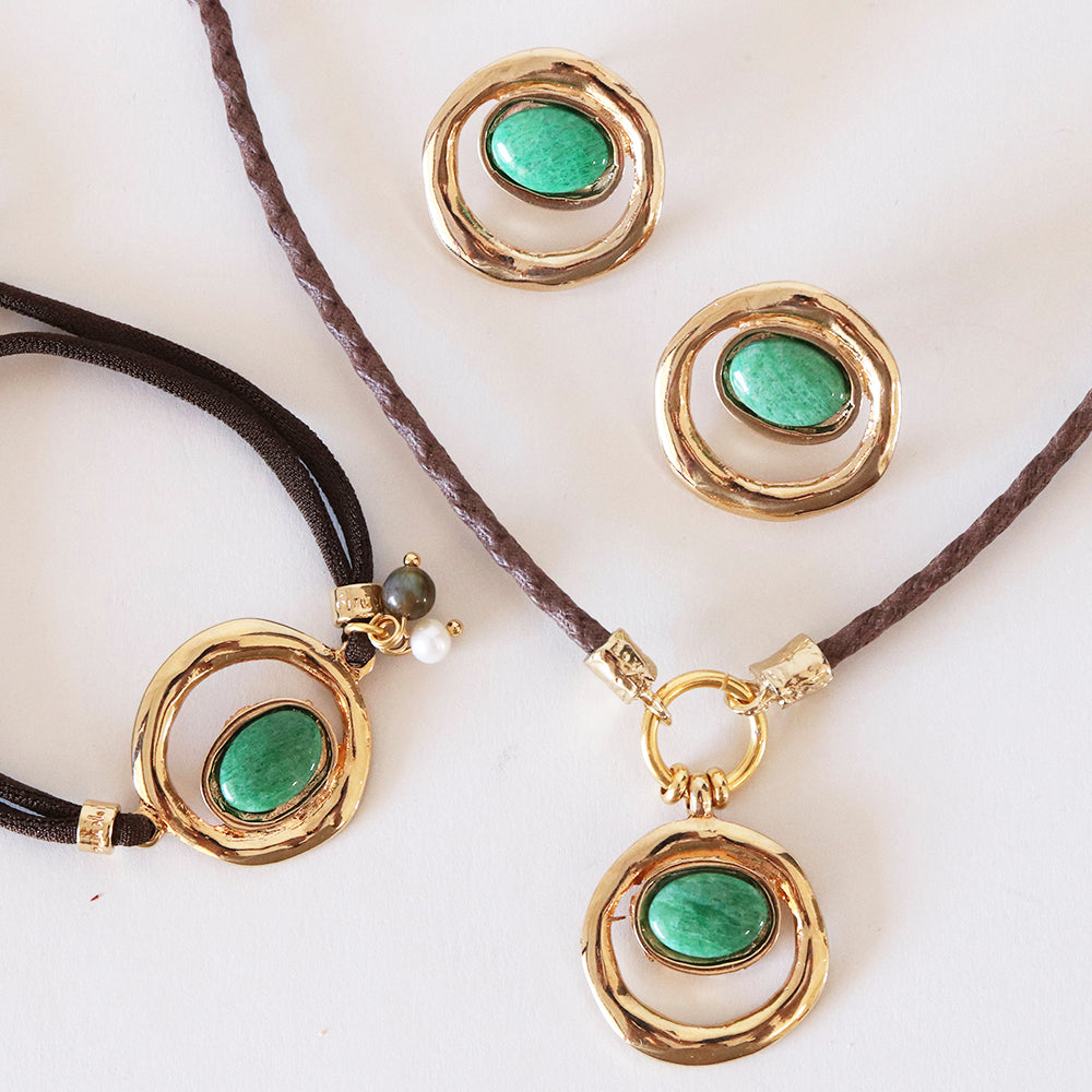 Conjunto de joyería: collar y aretes con piedras verde y detalles dorados en estilo orgánico y moderno.