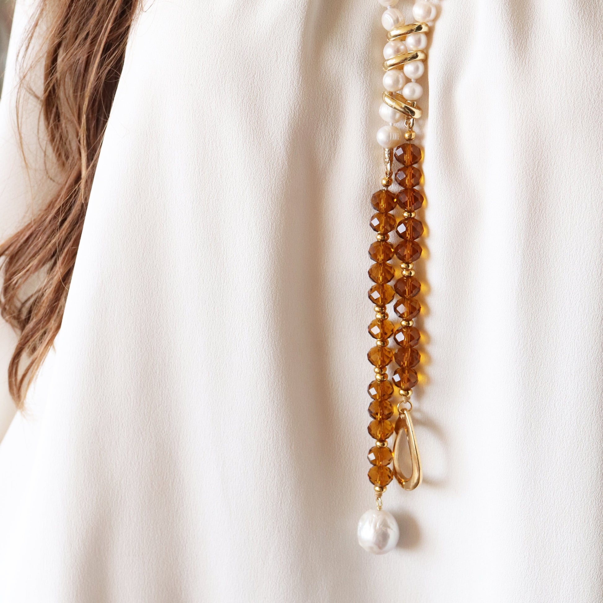 Collar elegante de perlas y cristal ámbar, con detalles dorados y acabado brillante, ideal para ocasiones especiales.