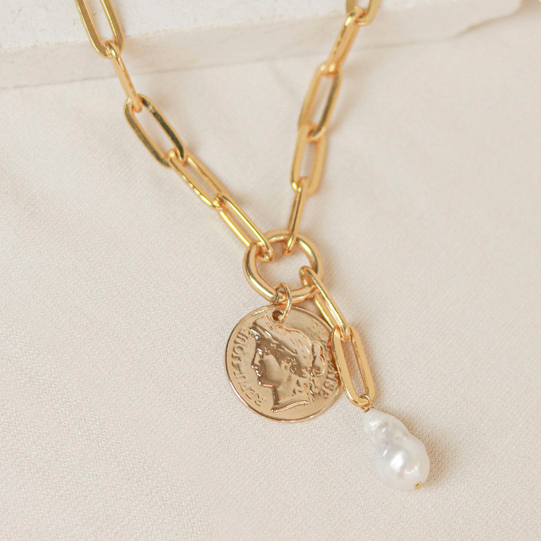 Collar dorado de eslabones con moneda y perla blanca, elegante y moderno. Perfecto para cualquier ocasión.