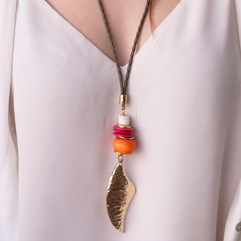 Collar bohemio de cuero marrón con colgante dorado y cuentas de colores vibrantes en tonos naranja y rosa.