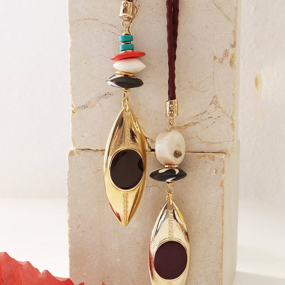 Collar moderno con colgante dorado y cuentas de colores, estilo bohemio y materiales mixtos.