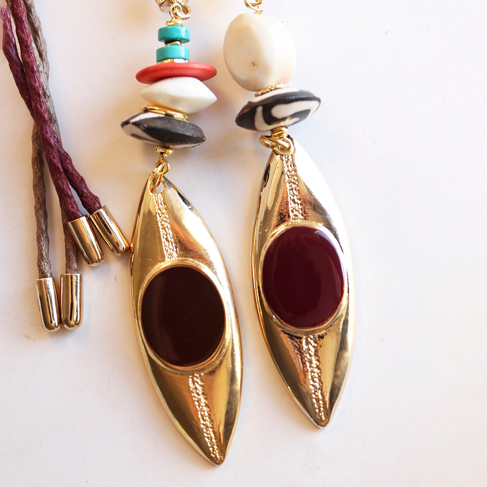 Pendientes dorados de diseño moderno con cuentas rojas, negras y verdes, estilo bohemio.