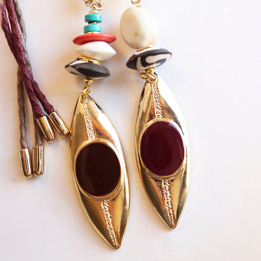 Pendientes dorados de diseño moderno con cuentas rojas, negras y verdes, estilo bohemio.