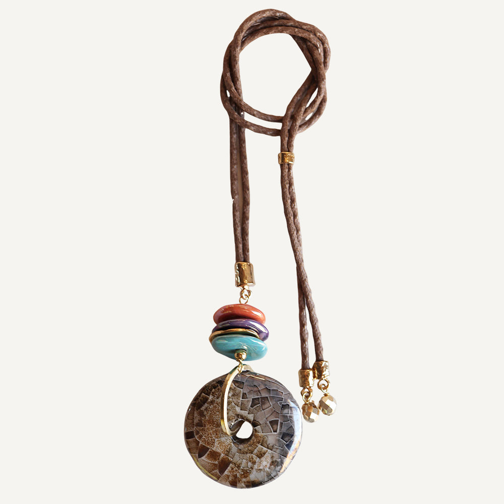 Collar de piedras naturales, cordón marrón, elementos multicolor, detalle dorado y estilo bohemio.