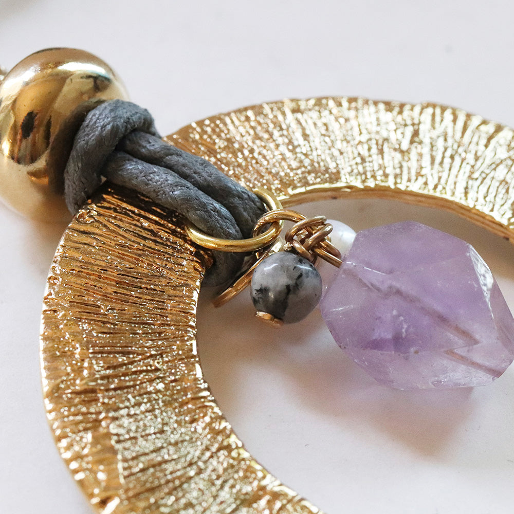 Pendientes de oro con textura, detalle de cuero gris y piedra preciosa de amatista.