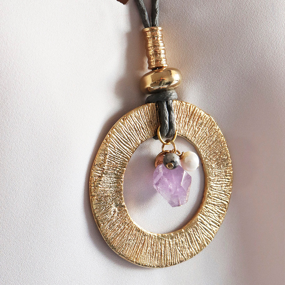 Collar de oro con colgante ovalado, cristal de amatista y perla, estilo bohemio y elegante.