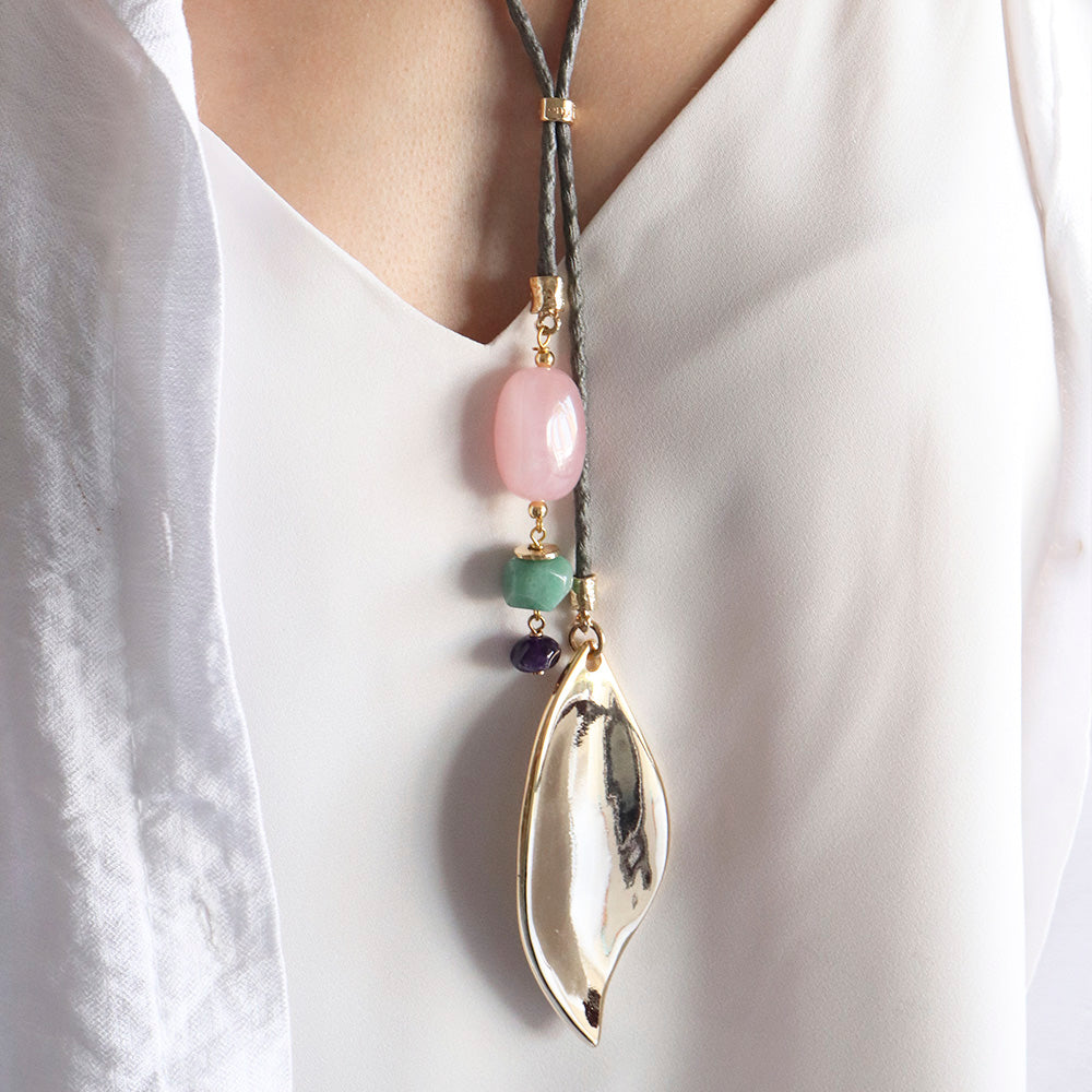 Collar largo bohemio con piezas de resina rosa y verde, y colgante dorado en forma de hoja.