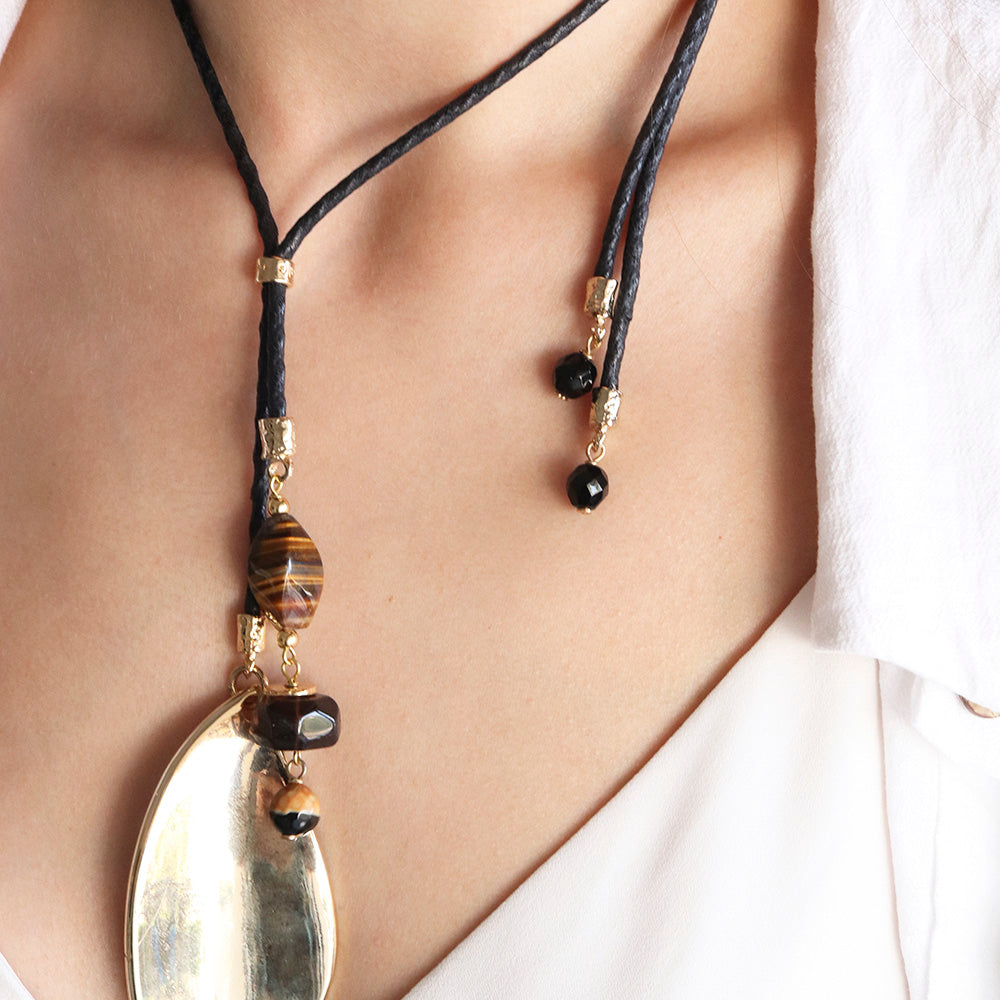 Collar bohemio en cuero negro con piedras ágata marrón, adornos dorados y colgante ovalado. Perfecto para cualquier ocasión.