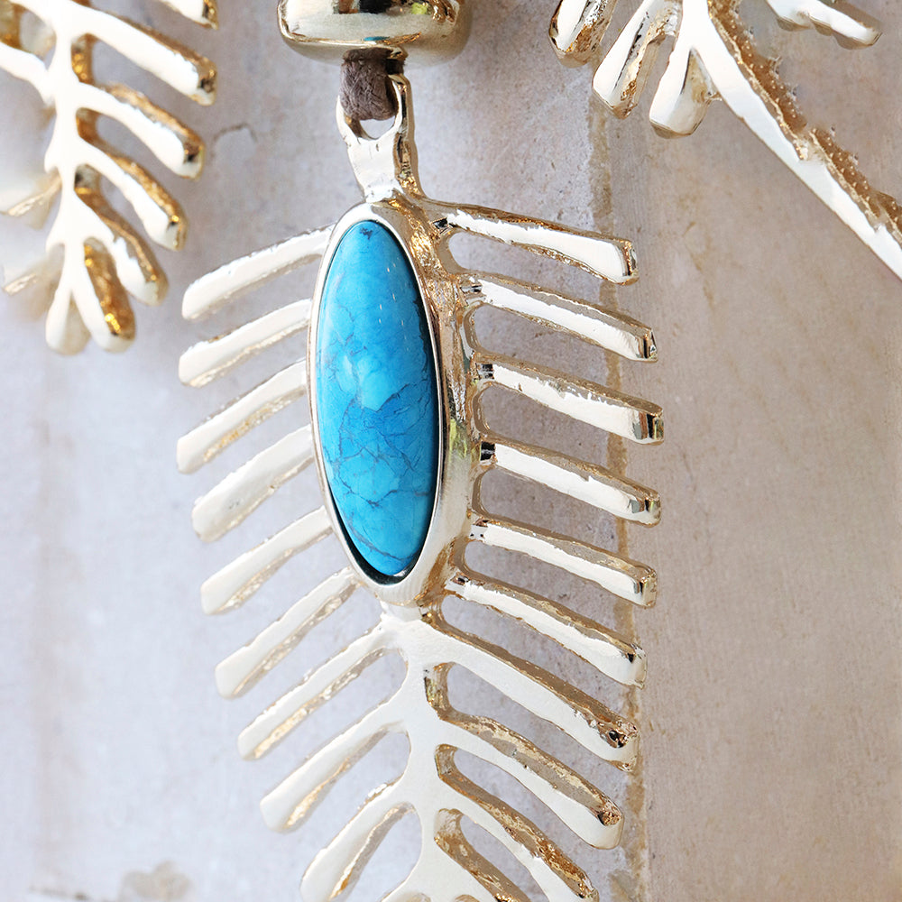 Pendiente de plata con diseño de hoja y piedra turquesa ovalada. Ideal para un estilo contemporáneo y elegante.
