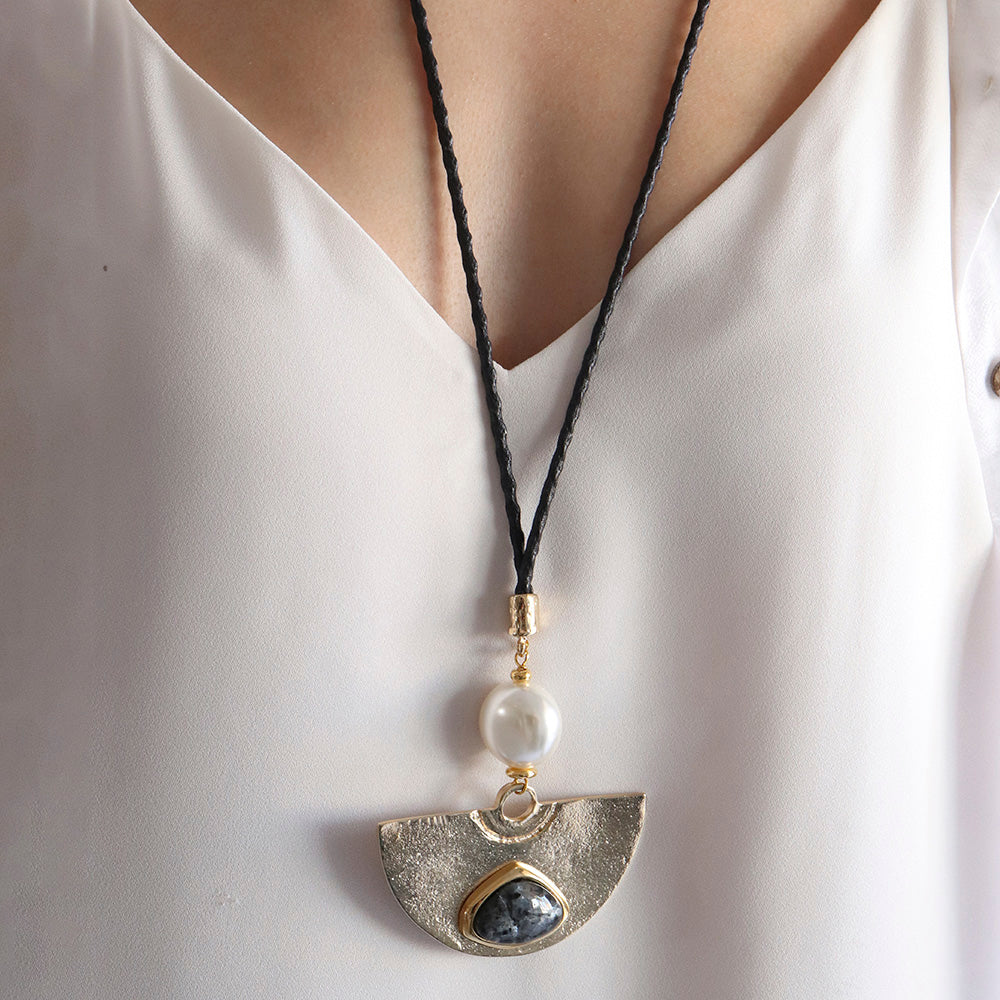 Collar bohemio con colgante dorado, perla blanca y piedra azul, cadena de cuero trenzado negro.