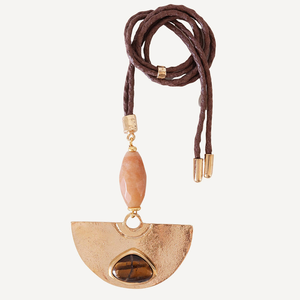 Collar bohemio con colgante dorado, piedra de tigre y cordón marrón. Ideal para looks casuales y elegantes.