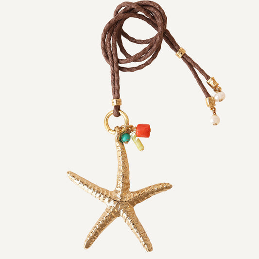 Collar de estrella de mar dorada con cordón marrón y detalles en turquesa y coral, estilo bohemio.