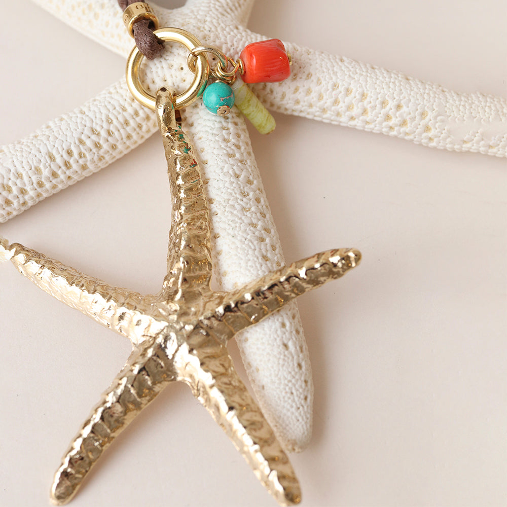 Colgante estrella de mar dorada con detalles en turquesa y coral, cadena de cuero, estilo bohemio.