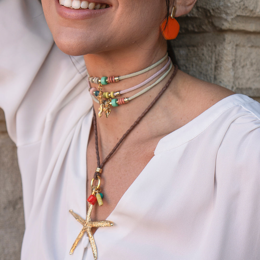 Collar de cuerda marrón con conchas, cuentas de colores y estrella de mar dorada, estilo bohemio.