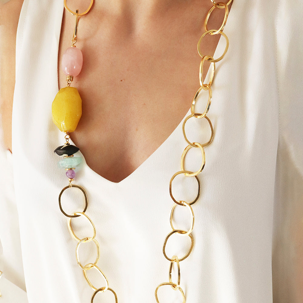 Collar largo de eslabones dorados con piedras de colores: rosa, amarillo, negro y verde. Ideal para looks modernos.