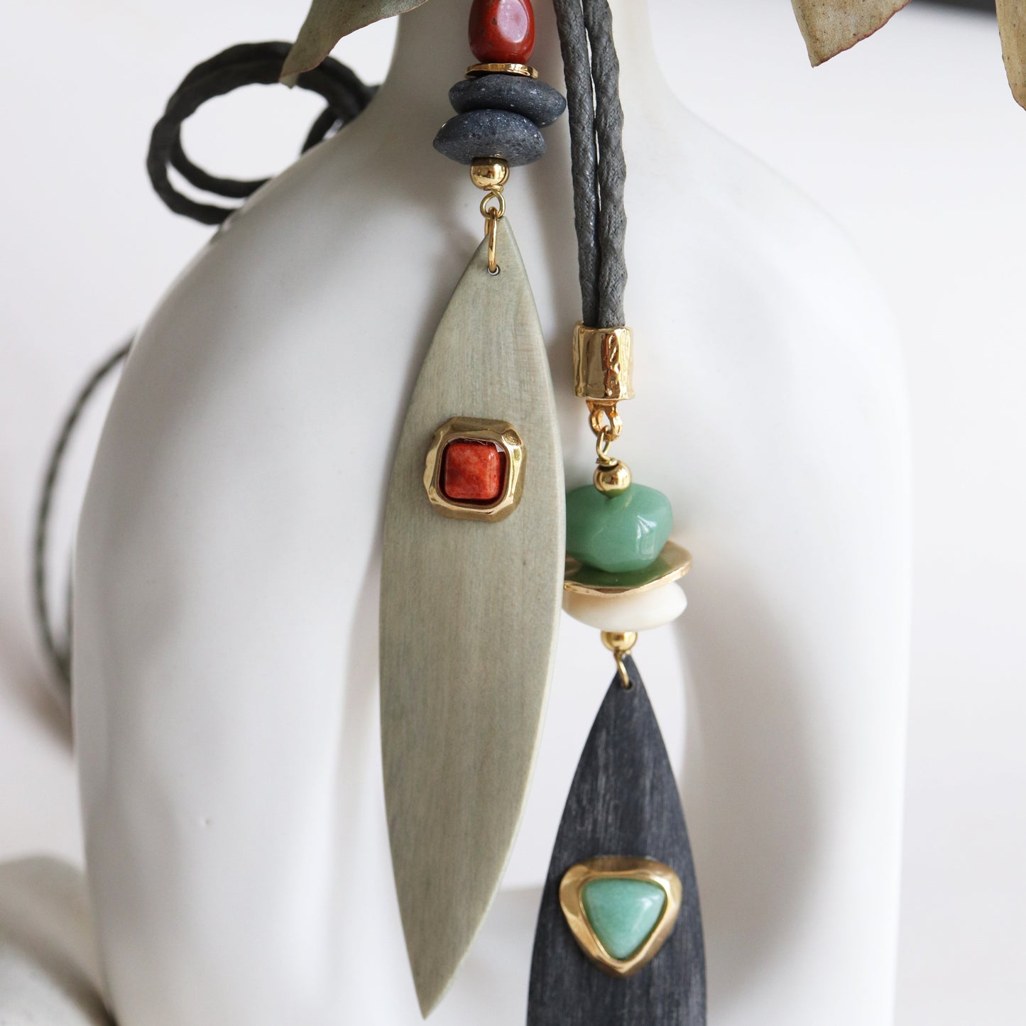 Collar moderno con piezas de madera verde y negra, cuentas rojas y verdes, y detalles dorados.