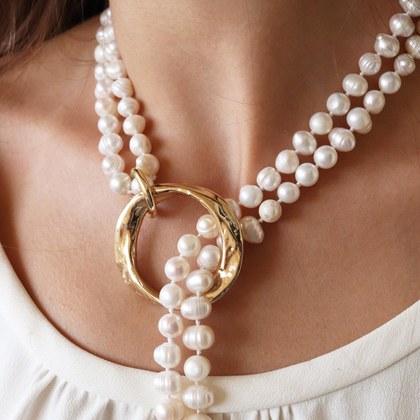 Collar de perlas blancas con anillo dorado, elegante y moderno, ideal para ocasiones especiales.