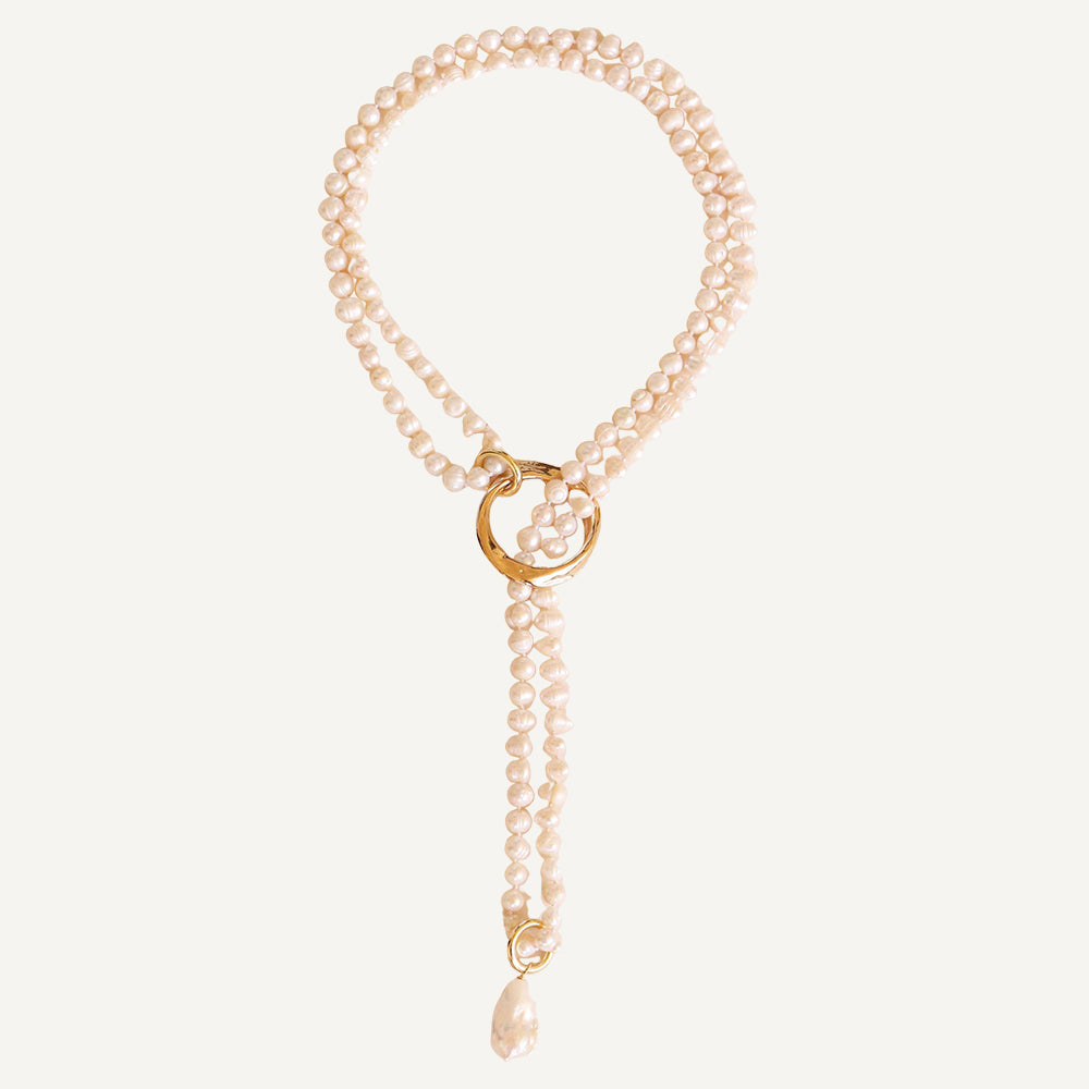 Collar de perlas blancas con anillo dorado y charm, estilo elegante y moderno.